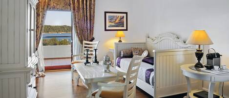 A bedroom with a bed, bedside table, lamp, and a view of the outdoors.