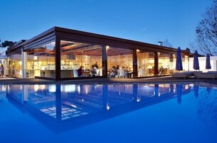 Una piscina al aire libre, sombrillas, tumbonas