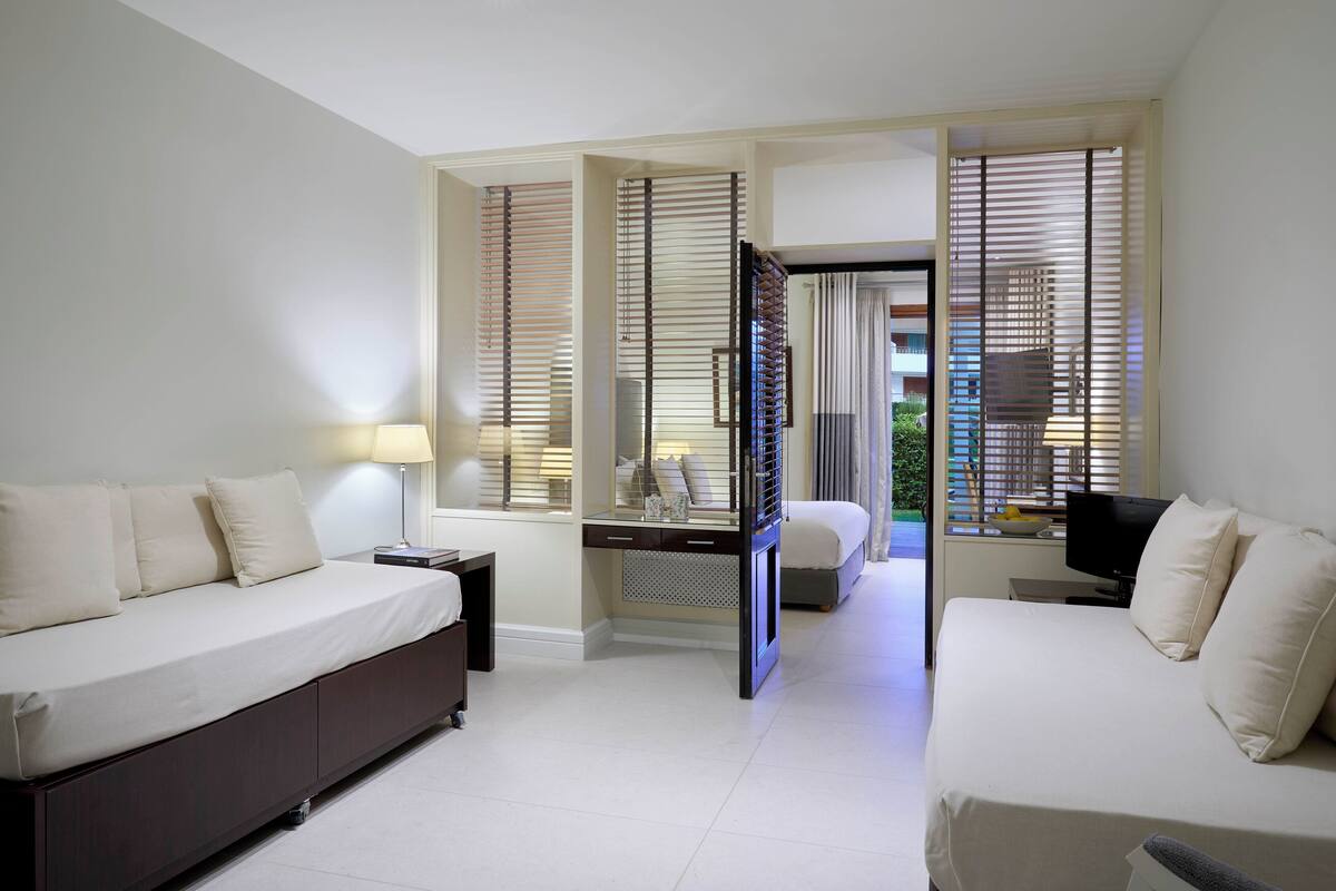 A modern hotel room with a large bed, a desk, and a TV.