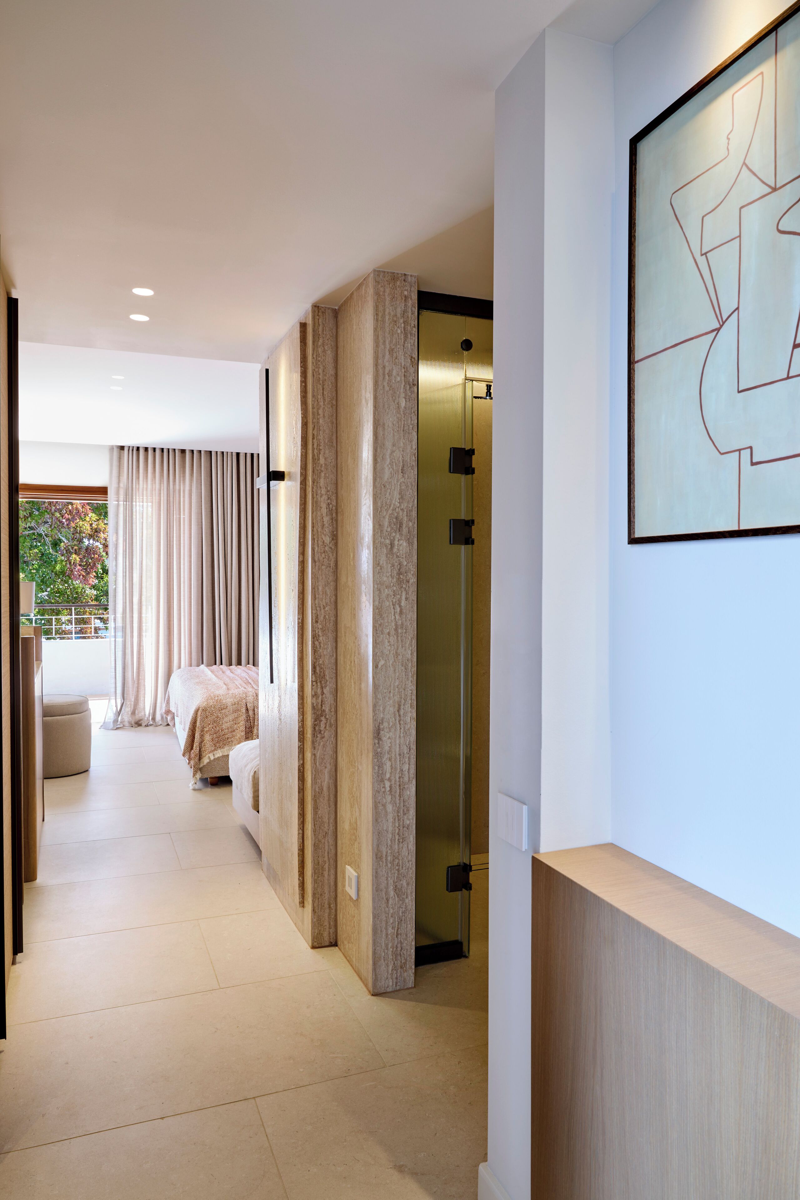 A modern hotel corridor with a bed, a shower, and a large abstract painting on the wall.