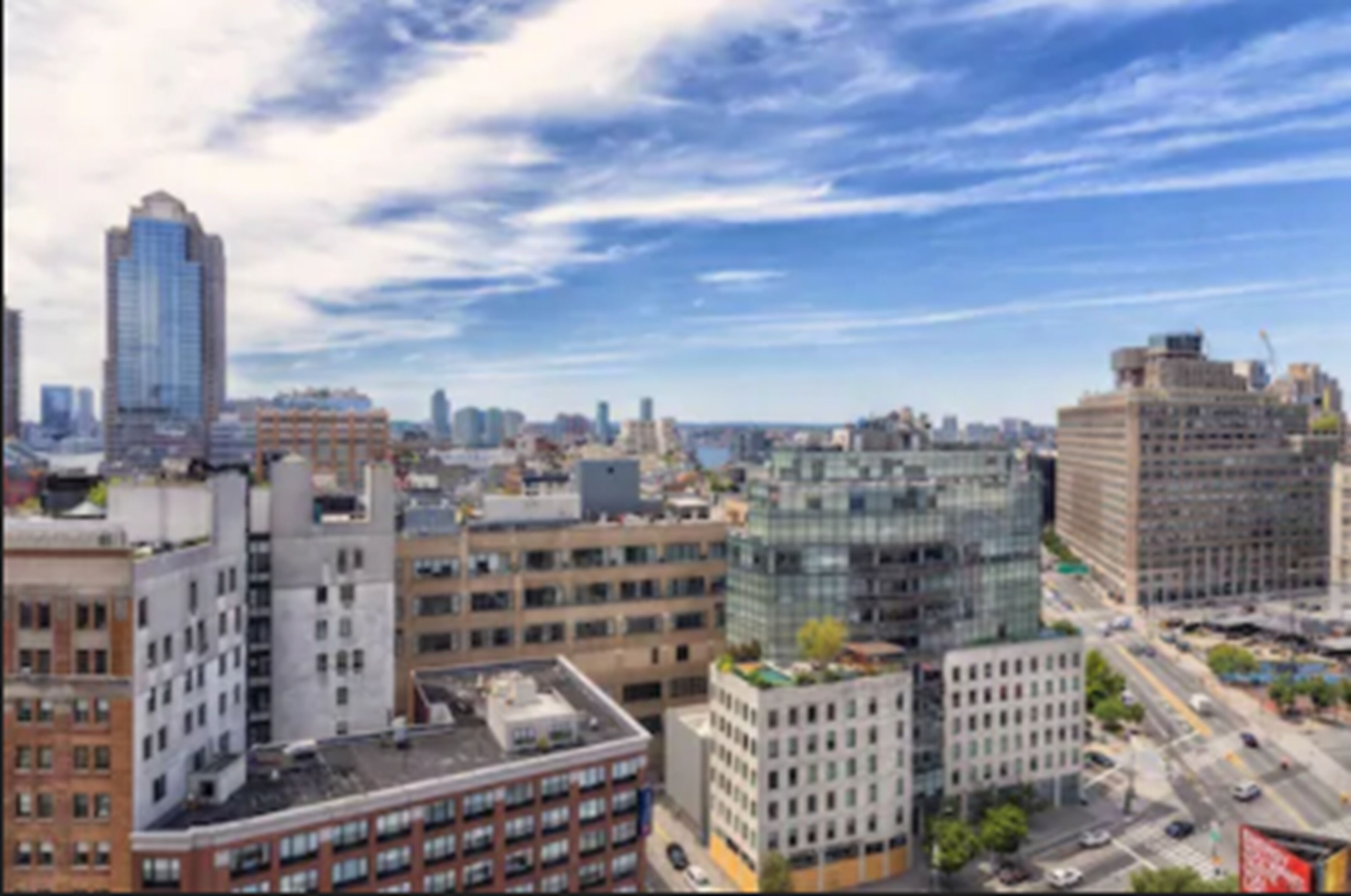A cityscape with various buildings, including a tall skyscraper and several mid-rise structures.