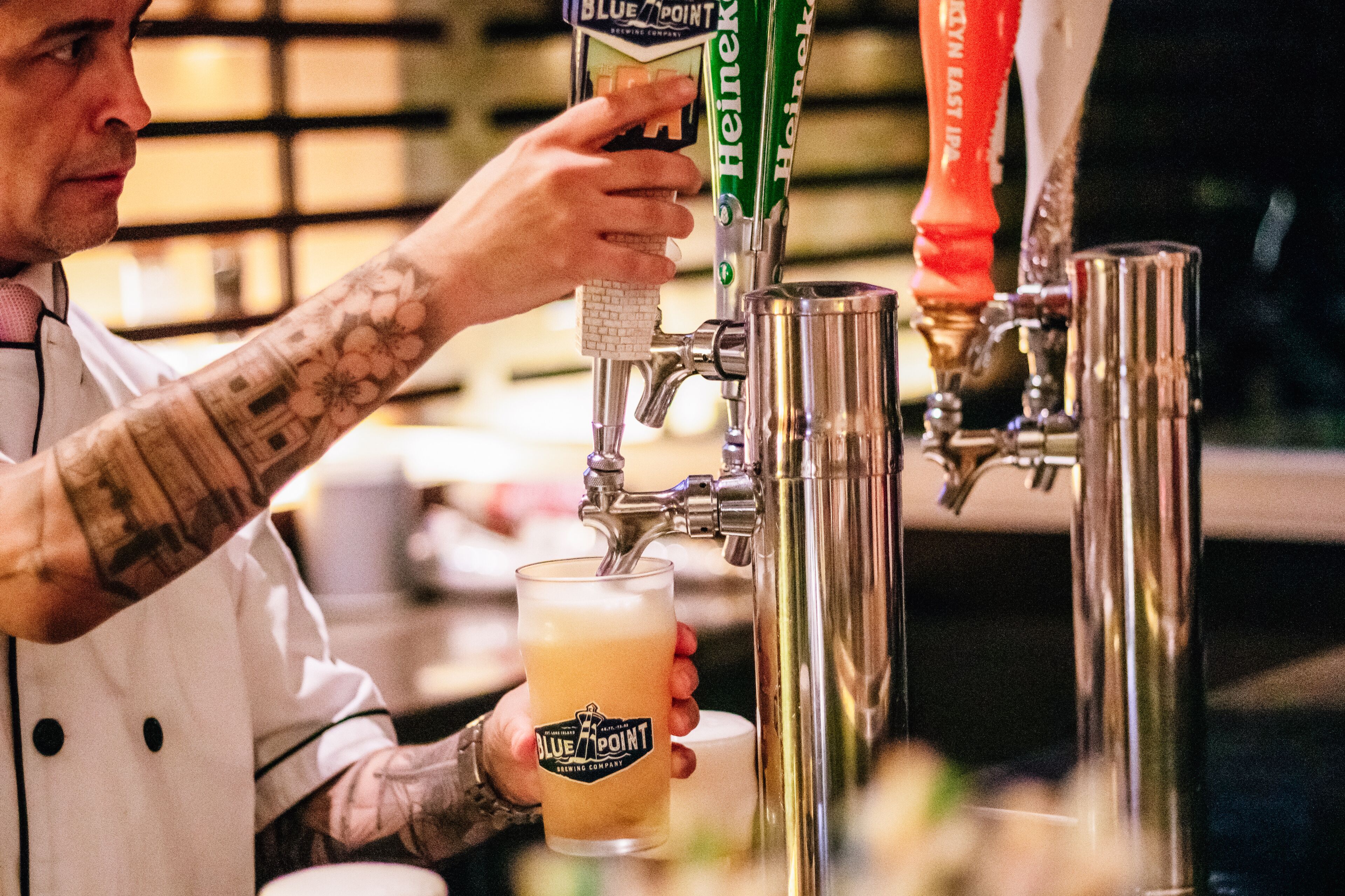 Una persona sirviendo cerveza de un grifo en un vaso.