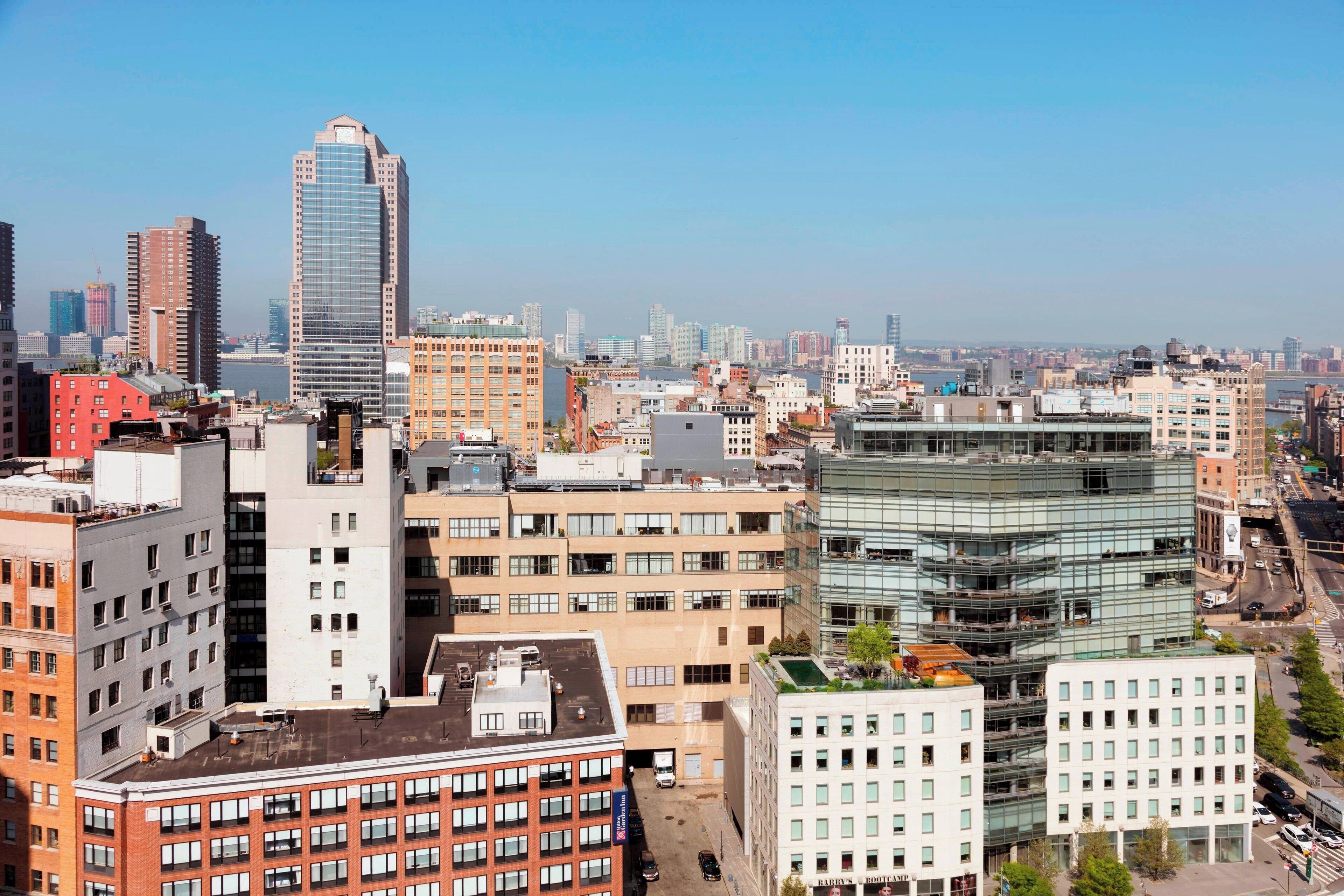 Un paisaje urbano con varios edificios, incluyendo un rascacielos destacado y varias construcciones de altura media.