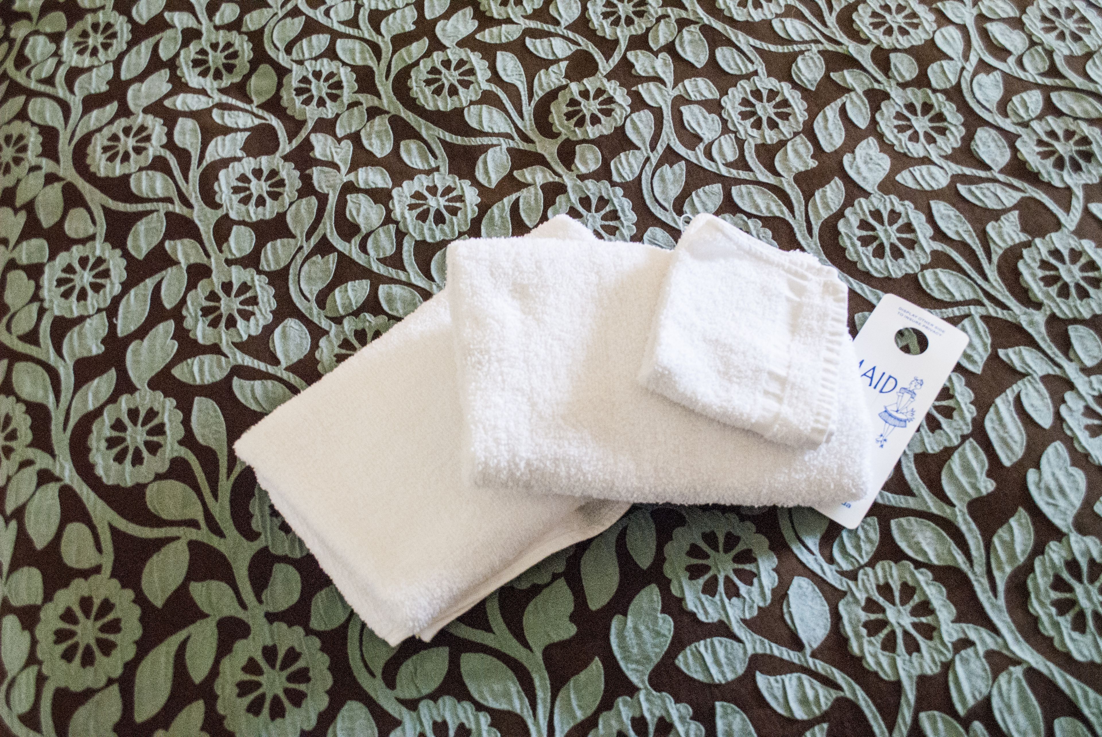 A white towel and a tag on a patterned fabric.