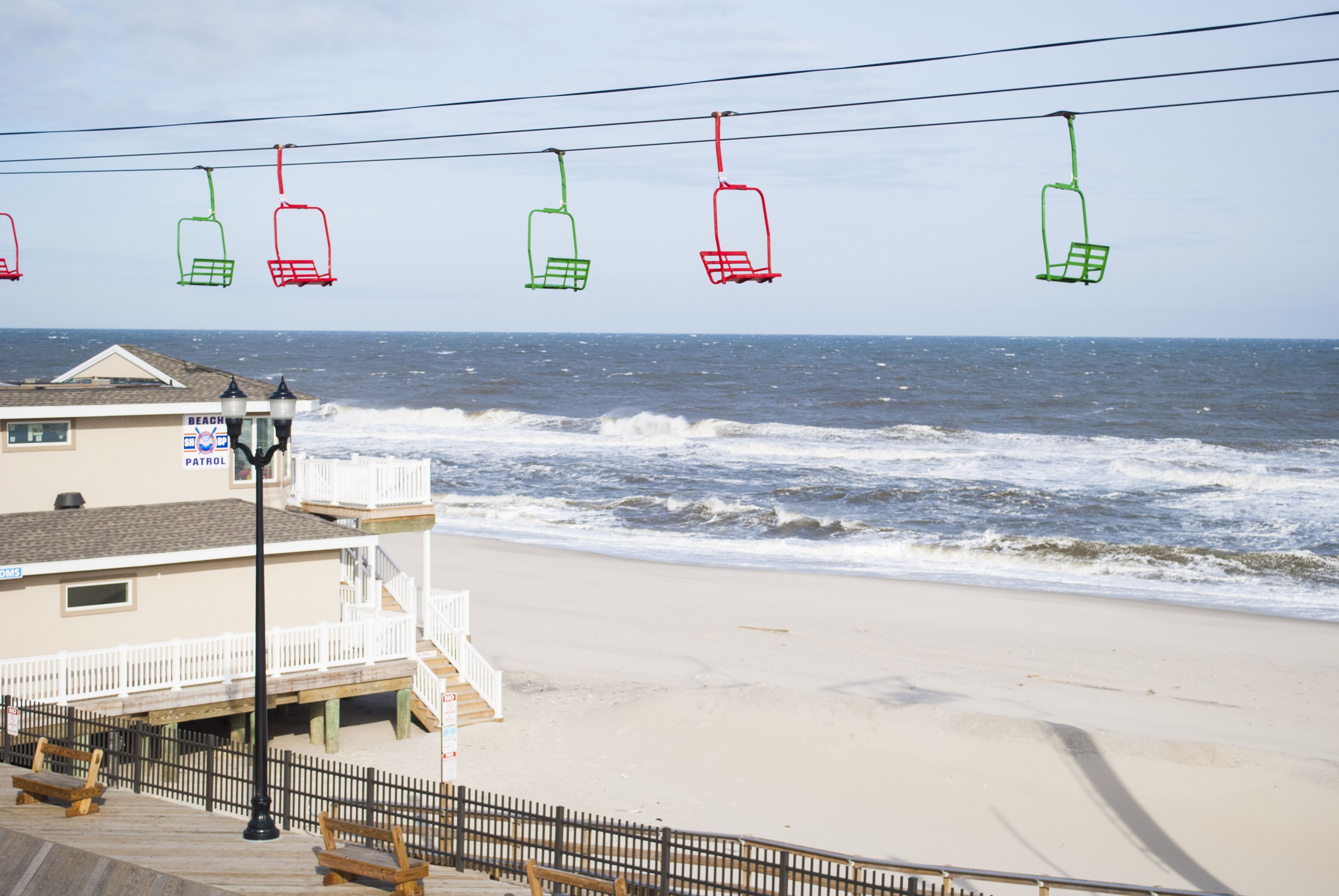 A beach with a lifeguard tower, a wooden boardwalk, and a building labeled "BEACH PATROL".