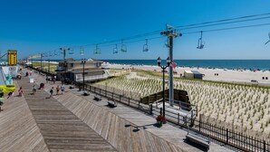 A boardwalk with a beach view, a sandy area with dunes, and a water body. - Boardwalk Hotel Charlee & Beach House Rentals (Seaside Heights)