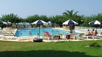 Relax by the serene pool surrounded by lush greenery and comfortable lounge chairs.