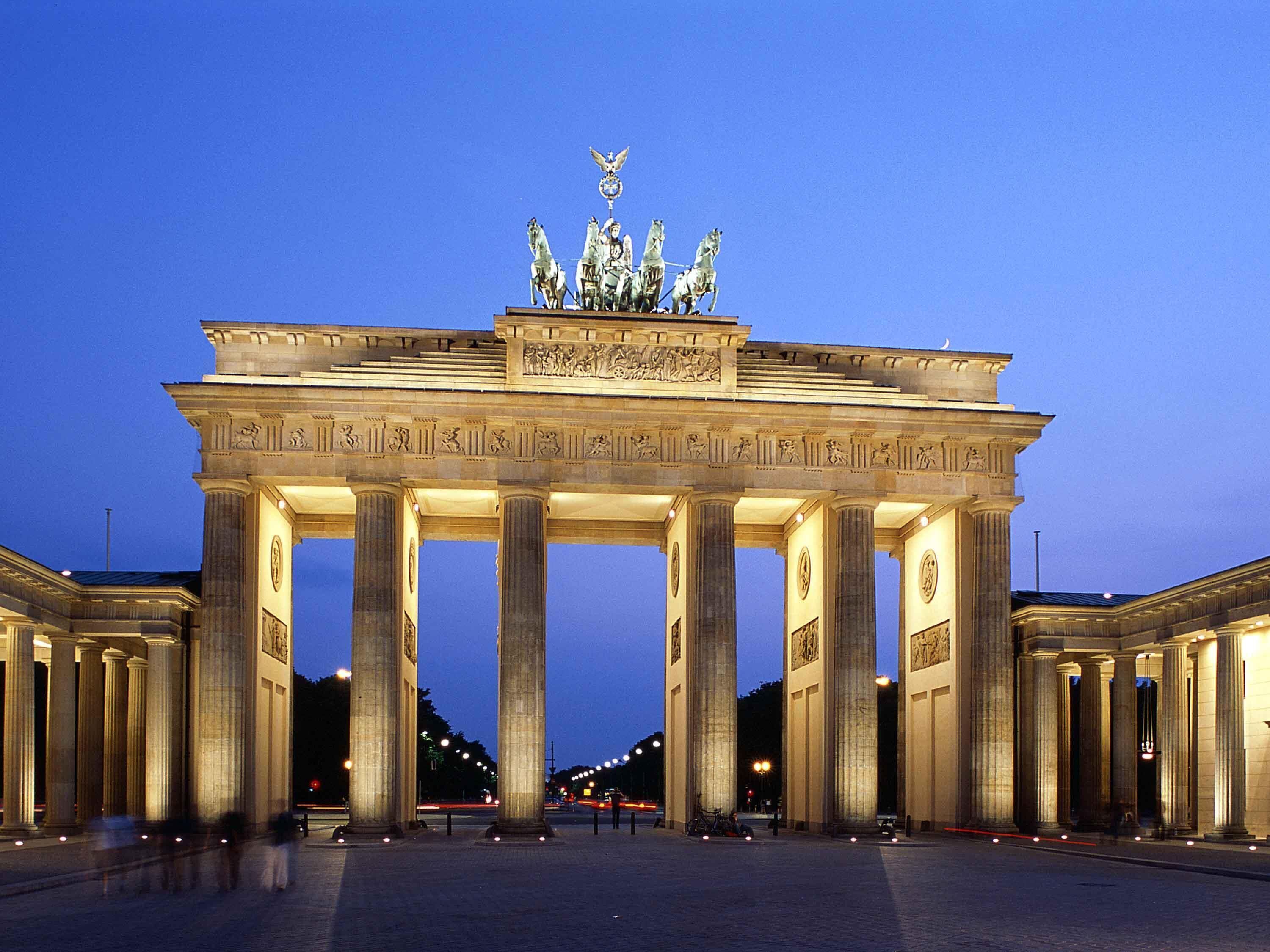 A grand, illuminated architectural structure with multiple columns and a central sculpture.