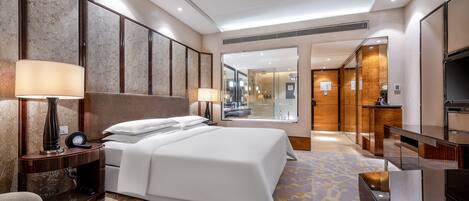 Habitación de hotel con una cama grande, lámparas de noche, escritorio y televisión.
