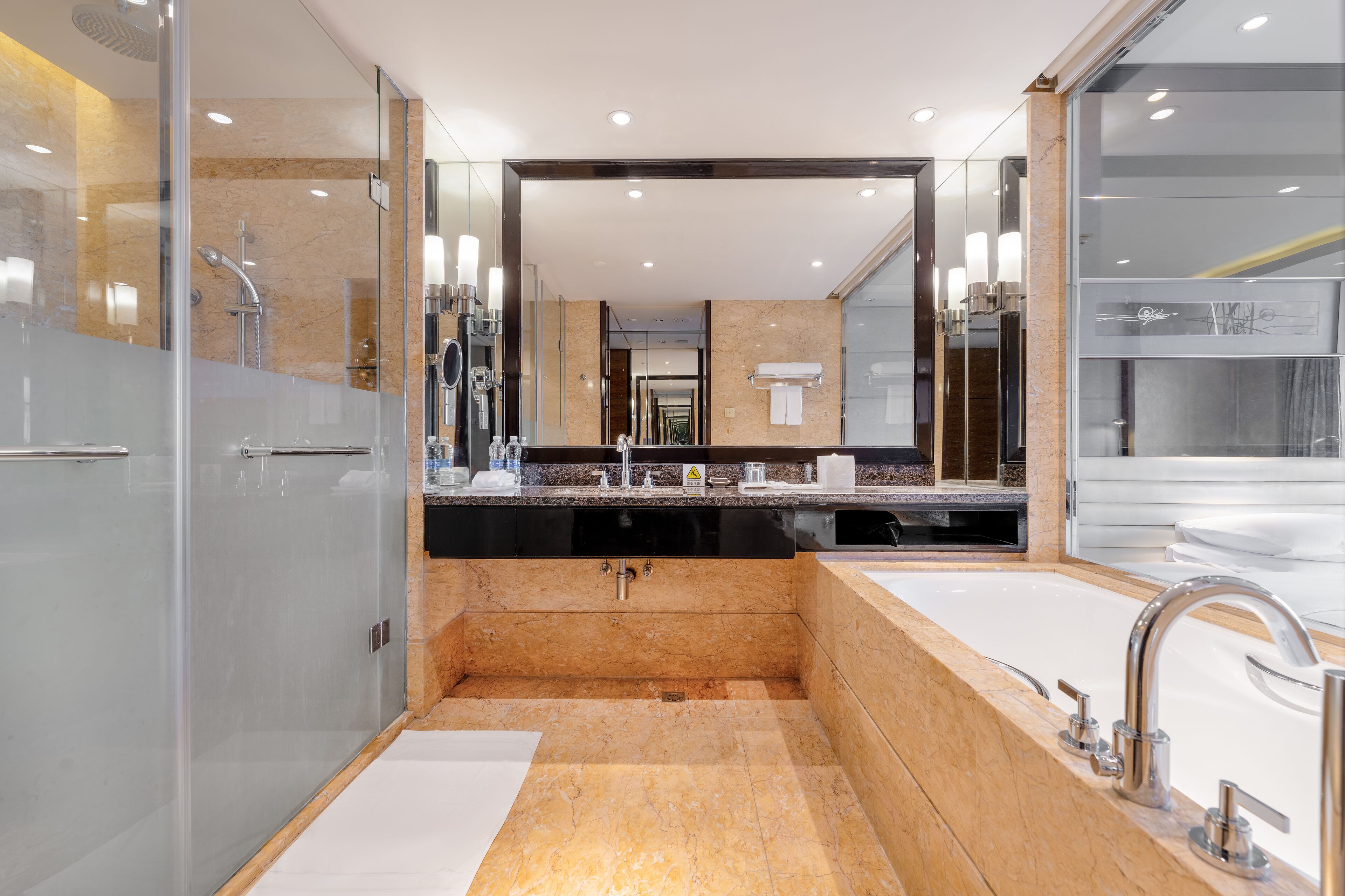 Une salle de bain moderne avec un grand miroir, deux vasques et un espace douche.