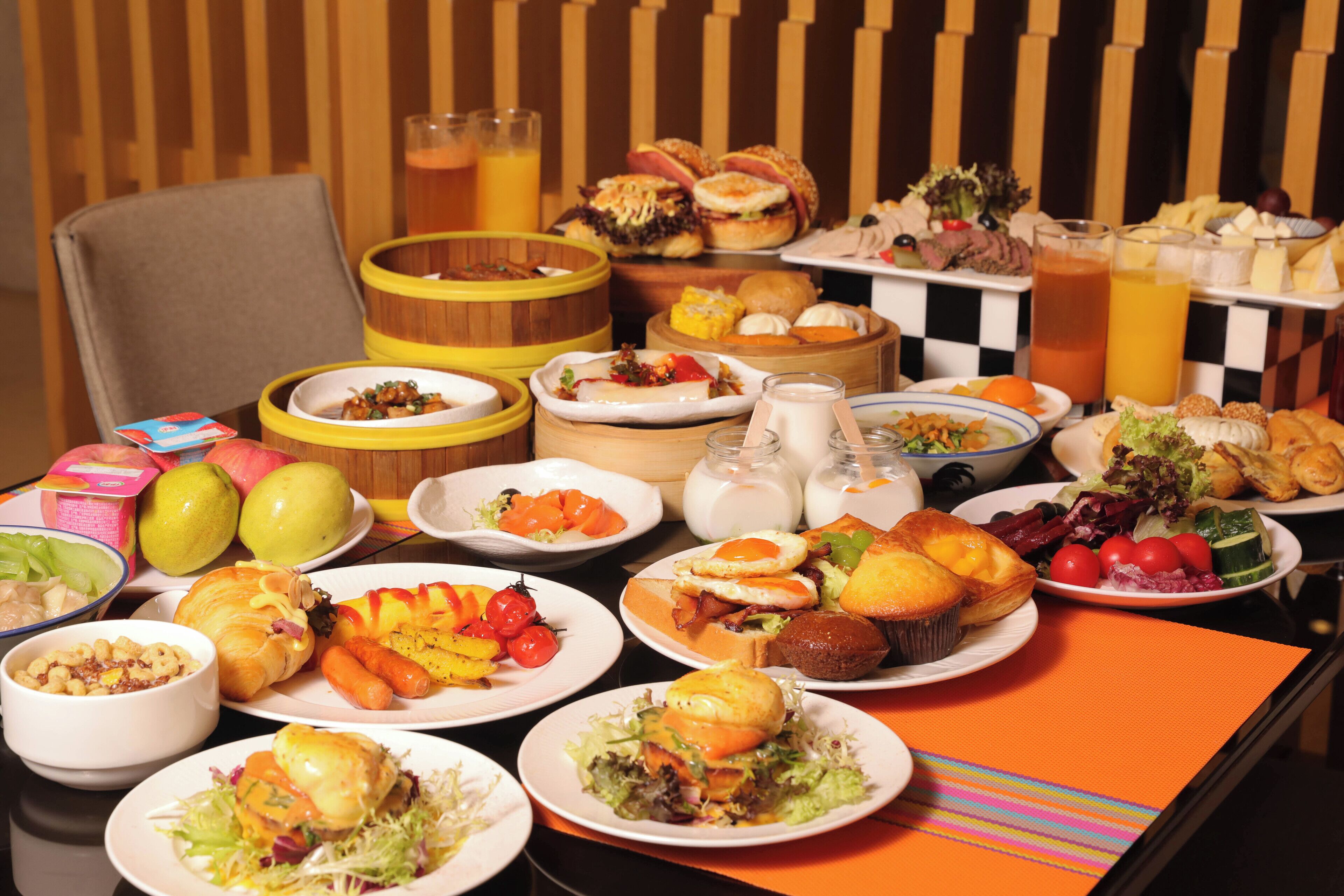 A buffet table with a variety of dishes including salads, meats, and pastries.