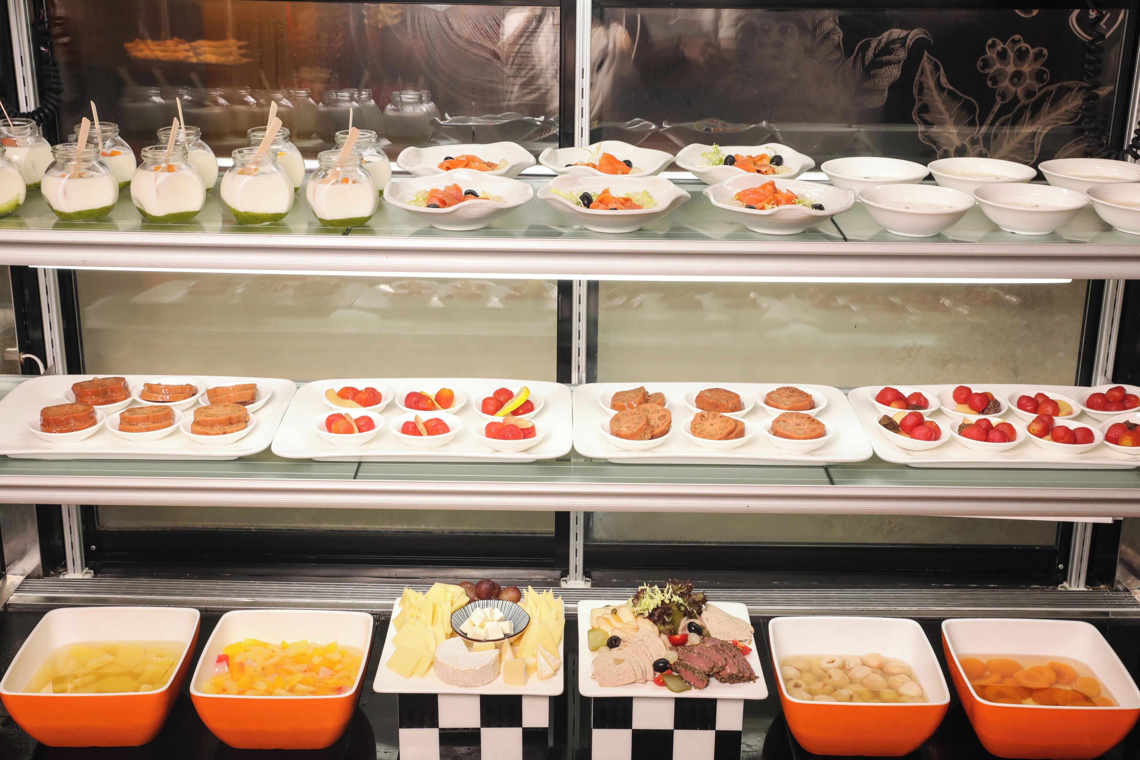 A buffet with various food items including fruits, salads, and desserts.
