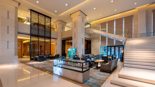 A spacious lobby with a glass coffee table, seating area, and a staircase. - Sheraton Zhongshan Hotel (Zhongshan)