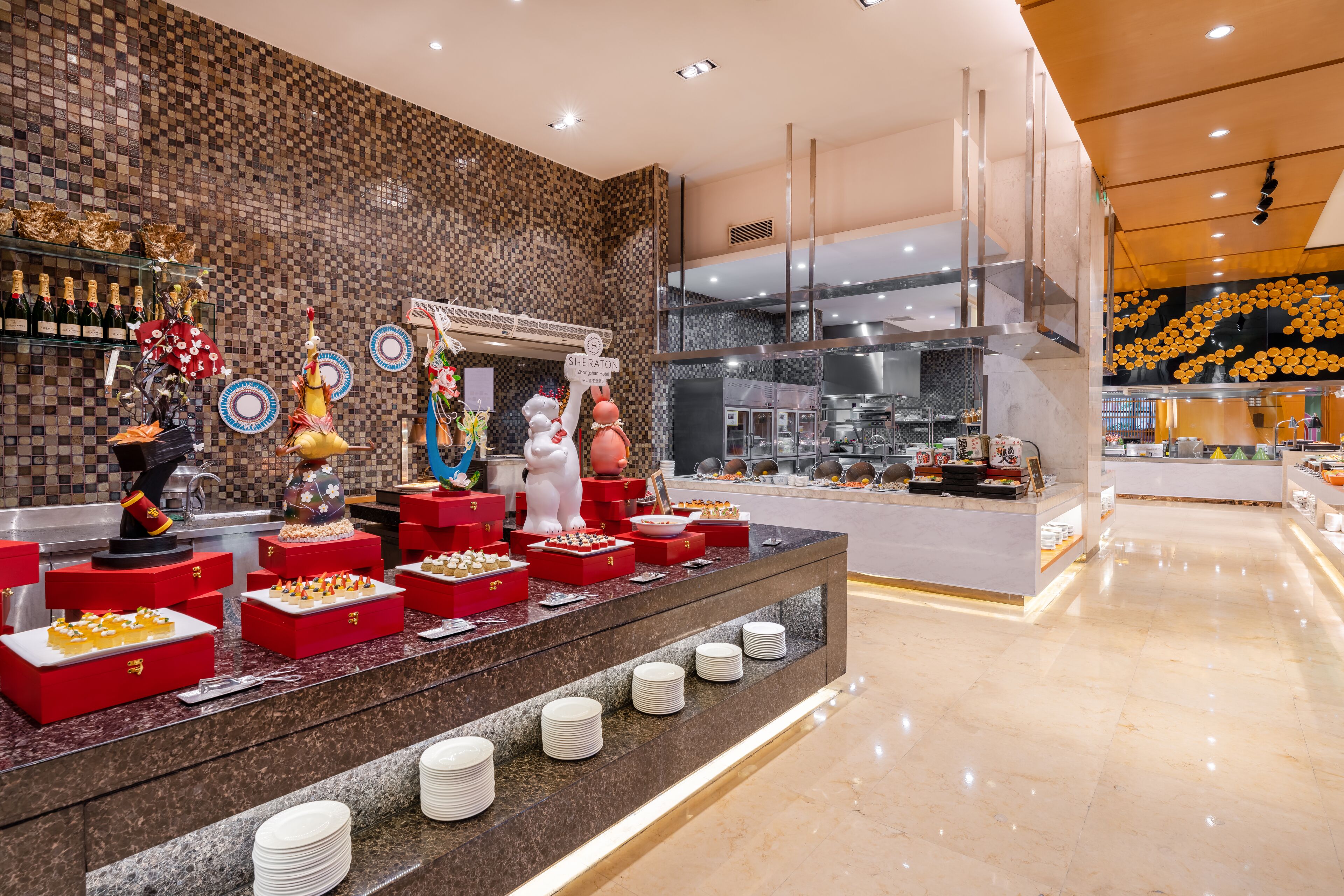 A buffet area with various food items and a kitchen in the background.