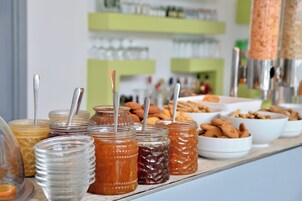 Una mesa de buffet con varios tarros de conservas y cuencos de nueces.