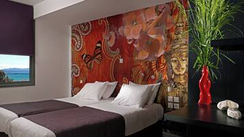 Een moderne slaapkamer met een groot bed, een decoratieve wand, een raam met uitzicht en een plant op een nachtkastje.