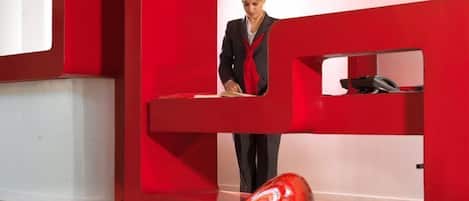 Un intérieur moderne agrémenté de touches de rouge et d’un fauteuil rouge au design unique et aux lignes courbes.