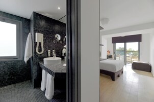 Un baño moderno con un lavamanos grande, un espejo y un perchero para toallas.