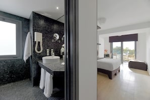 A modern bathroom with a large sink, mirror, and towel rack.