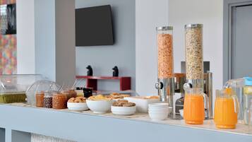 Een ontbijtbuffet met diverse soorten eten en een koffieapparaat.
