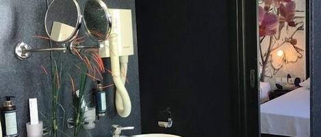 A modern bathroom with two sinks, a hairdryer, and a mirror.