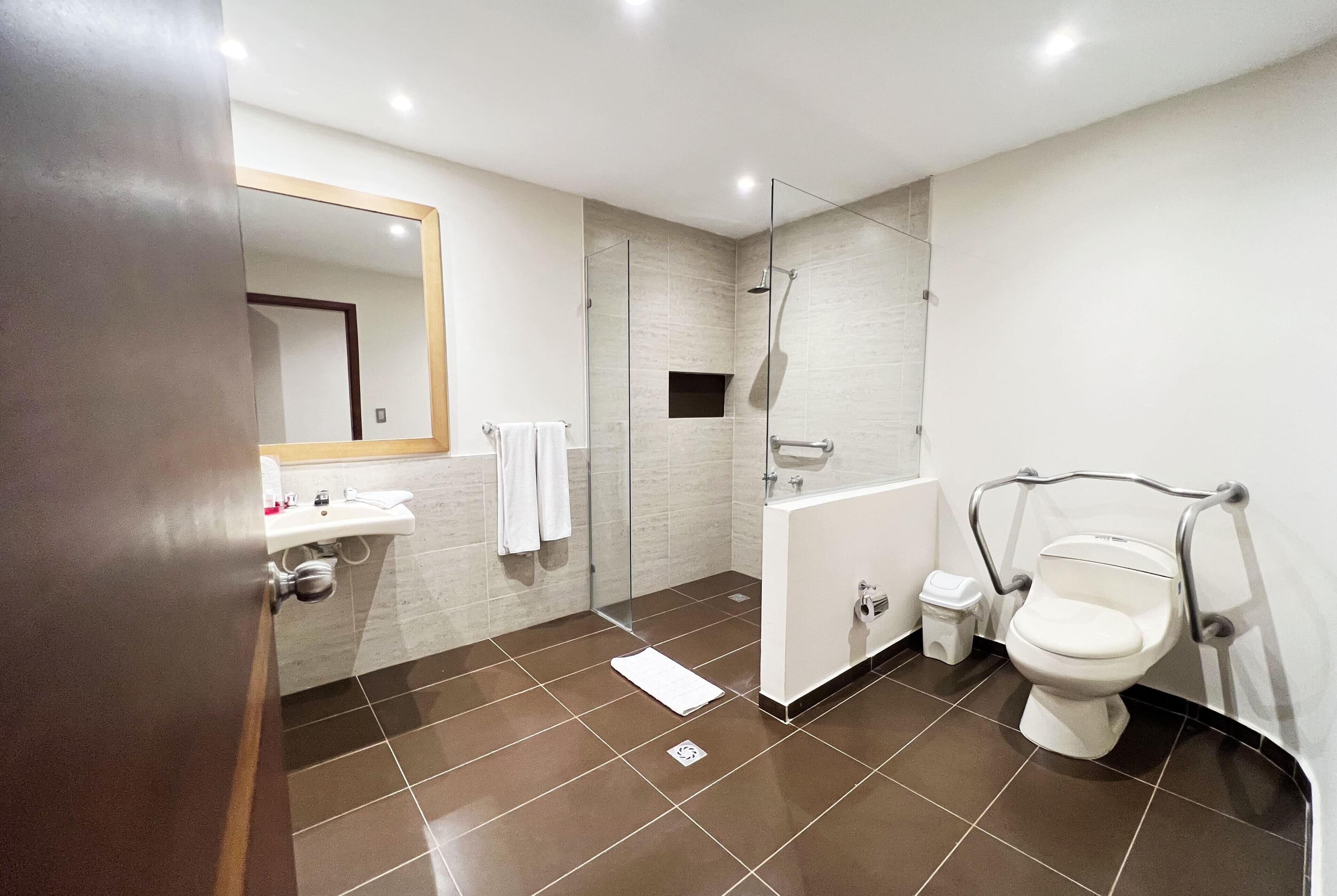 Un baño moderno con ducha, inodoro y lavamanos.