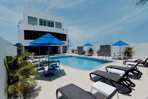 Una piscina al aire libre, sillones reclinables de piscina