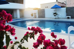 Una piscina al aire libre, tumbonas