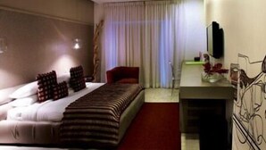 A hotel room with a bed, a desk, a chair, and a TV. - The Park Pod (Chennai)