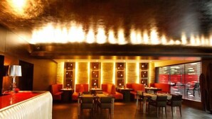 A dimly lit lounge area with red seating and a bar. - The Park Pod (Chennai)