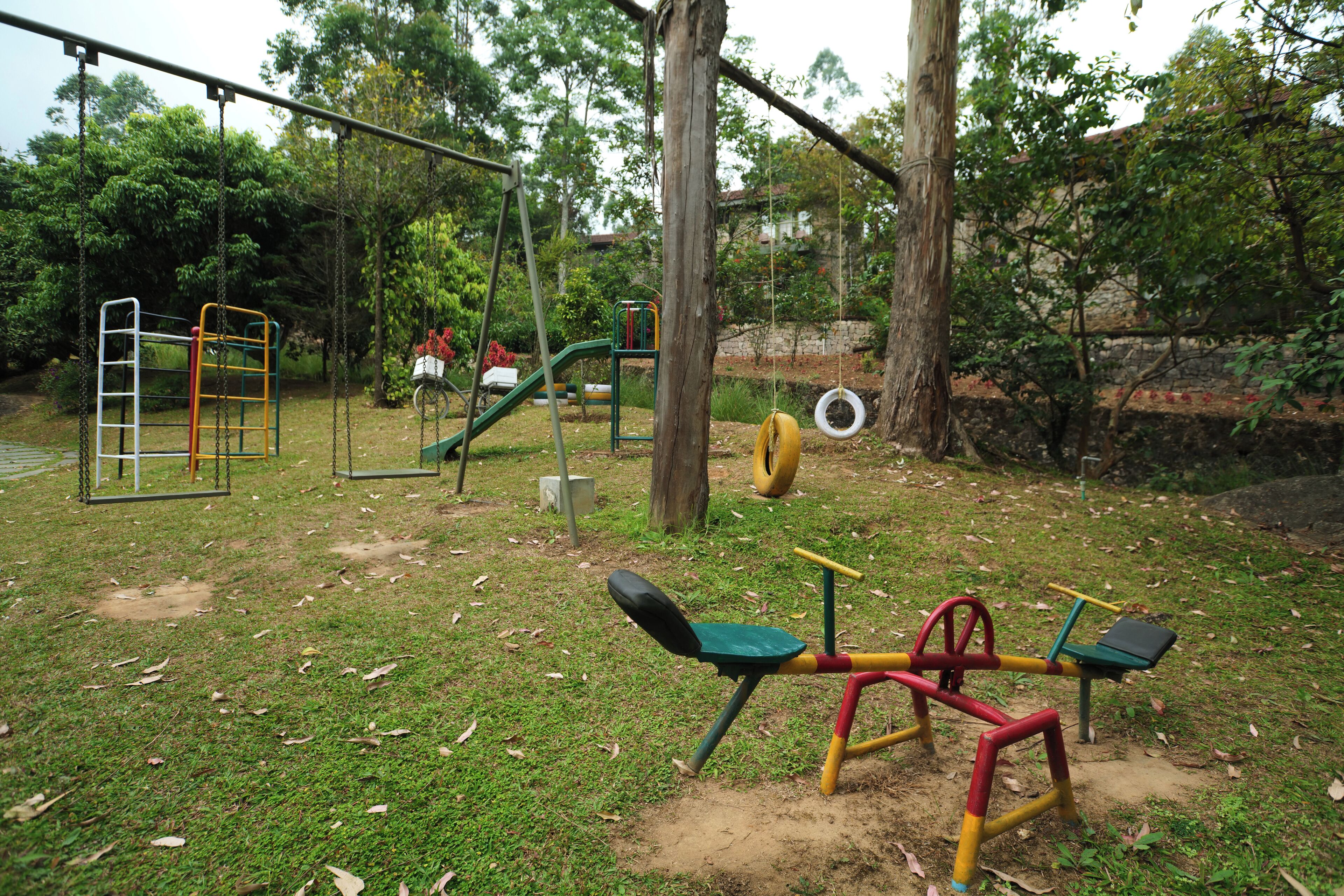 A playground with swings, a slide, and a seesaw.