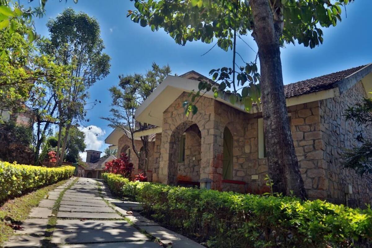 Um edifício de pedra com janelas em arco e um caminho que leva até ele.