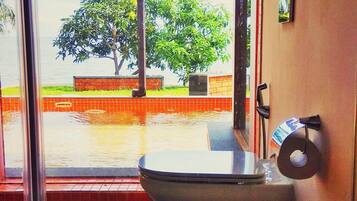 Un baño con lavamanos, inodoro y ventana.
