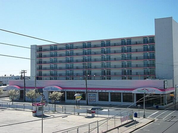 A multi-story hotel with a row of balconies, a drive-thru, and a visible sign for a restaurant. - Beach Terrace Motor Inn (Wildwood)