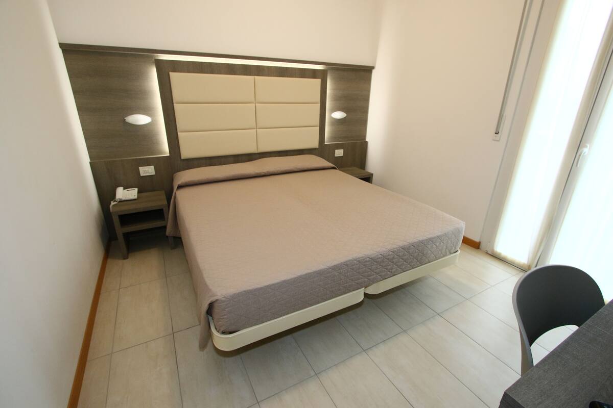 Une chambre à coucher avec un lit, des tables de chevet et une chaise.
