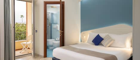Una habitación de hotel con cama, baño y balcón.