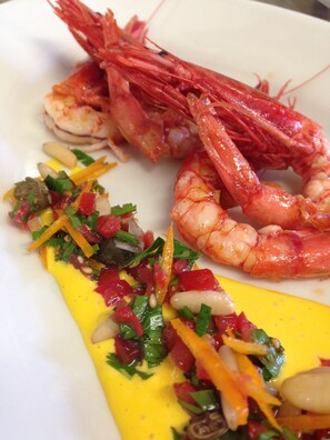 A plate with two cooked shrimp and a colorful vegetable garnish. - Casa Yvorio (Terracina)