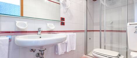 A modern bathroom with a glass shower enclosure, a white sink, and a bathtub.