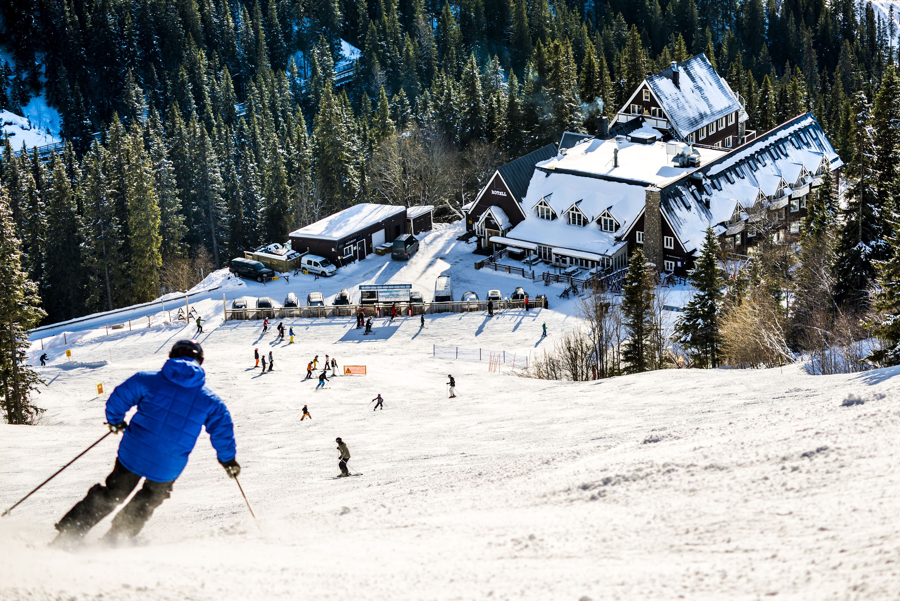 Una stazione sciistica con un ampio albergo, piste da sci e una montagna sullo sfondo.
