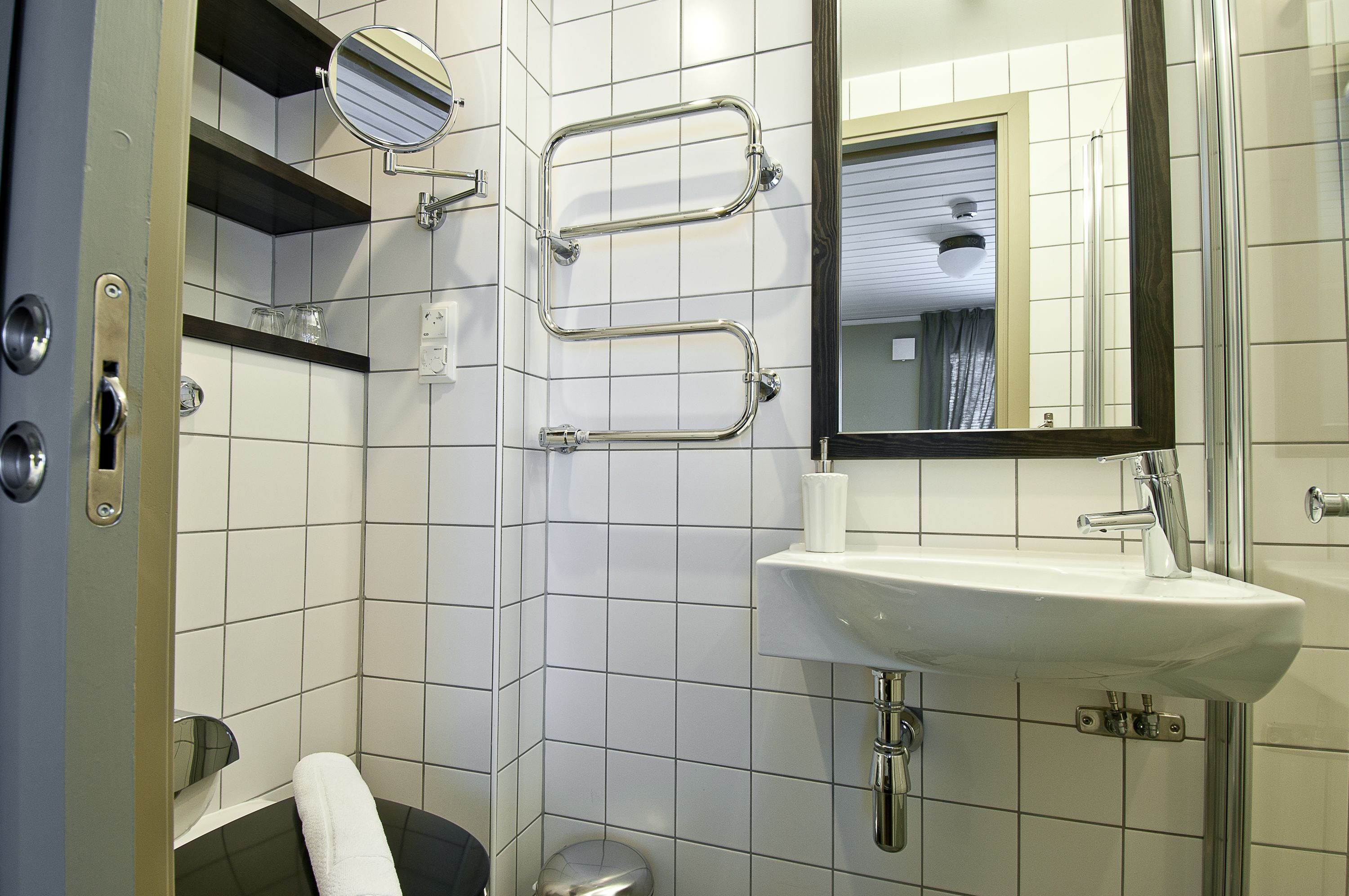 Ein Badezimmer mit Waschbecken, Spiegel und Chromarmaturen.