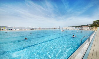 En la playa, sombrillas, vóleibol de playa, 2 bares en la playa