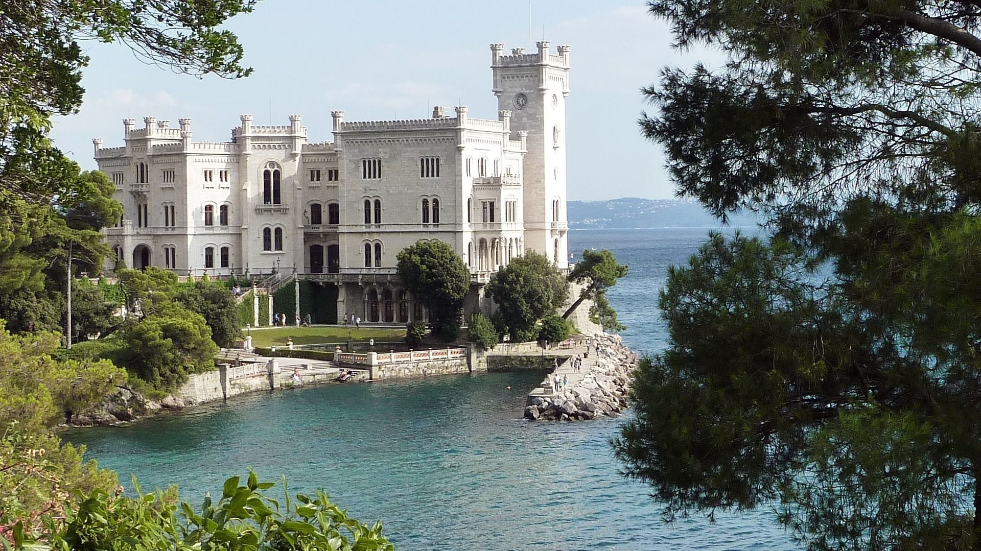Ein großes, historisches Gebäude mit mehreren Türmen und Blick auf das Wasser.