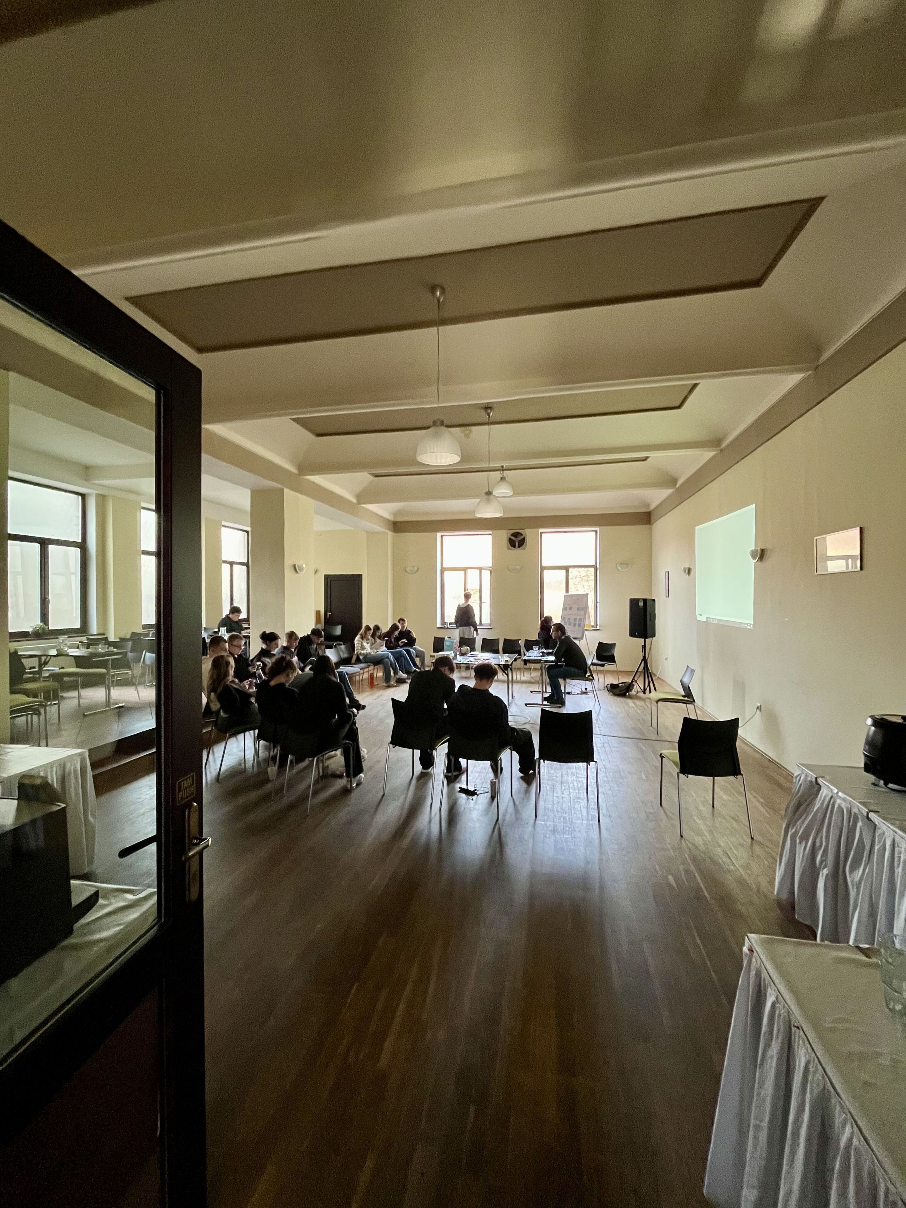Une salle de conférence équipée d’une longue table, de chaises, d’un projecteur et d’un écran.
