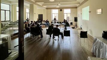 Une salle de conférence équipée d’une longue table, de chaises, d’un projecteur et d’un écran.