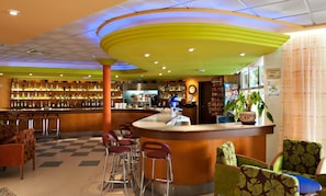 A bar area with stools, a counter, and shelves with bottles. - Alone (Finestrat)