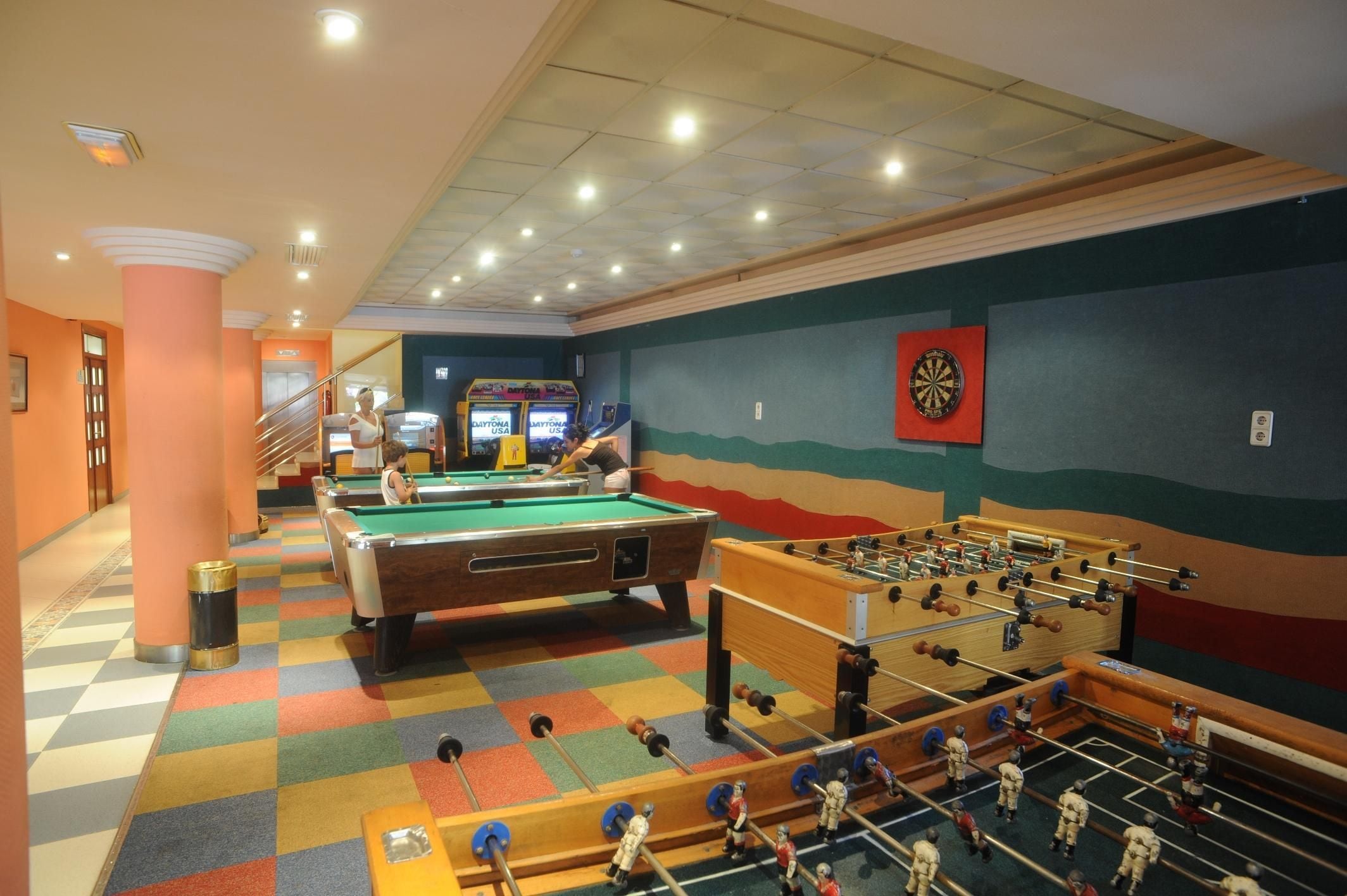 A recreational area with pool tables, a foosball table, and arcade games.