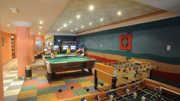 A recreational area with pool tables, a foosball table, and arcade games.