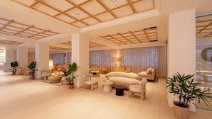 Een ruime, moderne woonruimte met een hoge plafond, comfortabele zitplaatsen en potplanten.