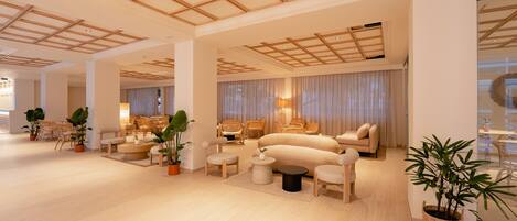 A spacious, modern living area with a high ceiling, comfortable seating, and potted plants.