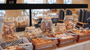 Un bufé con diversos alimentos en frascos y bandejas de madera.